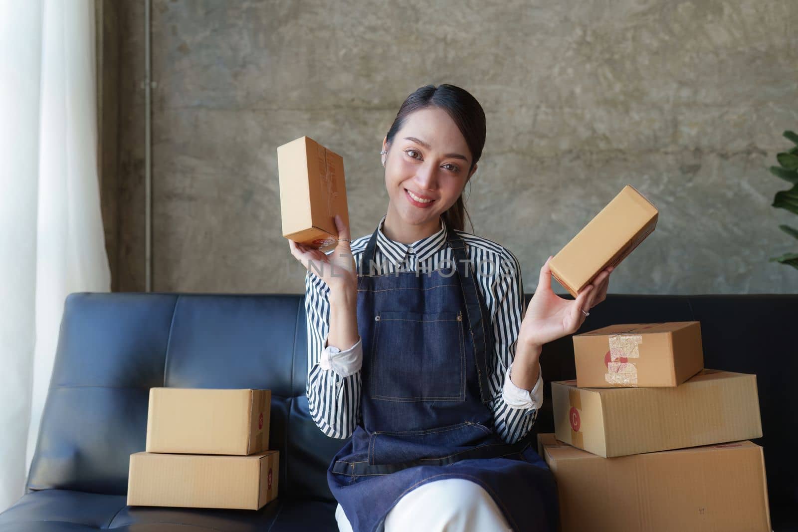 Beautiful Businesswoman start small business. A woman works from home delivering parcels online. Entrepreneurs, SME delivery concept by itchaznong