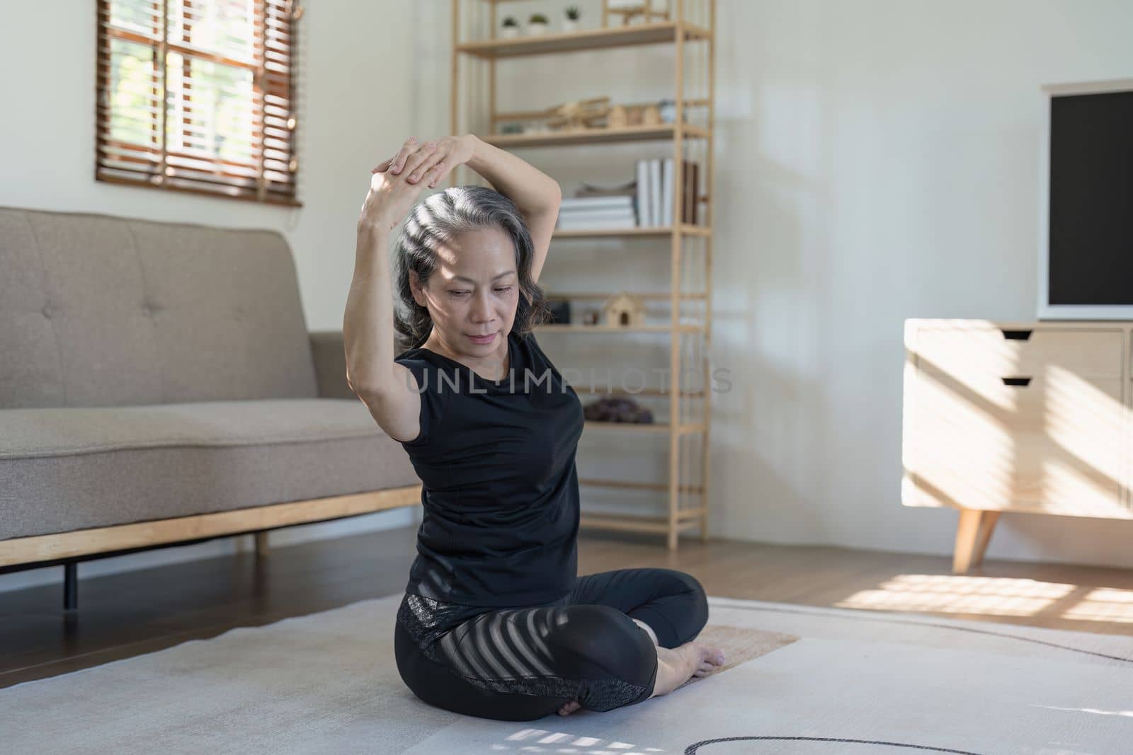 Portrait of Mature Woman doing stretching yoga side bend. exercise and stretching concept by itchaznong