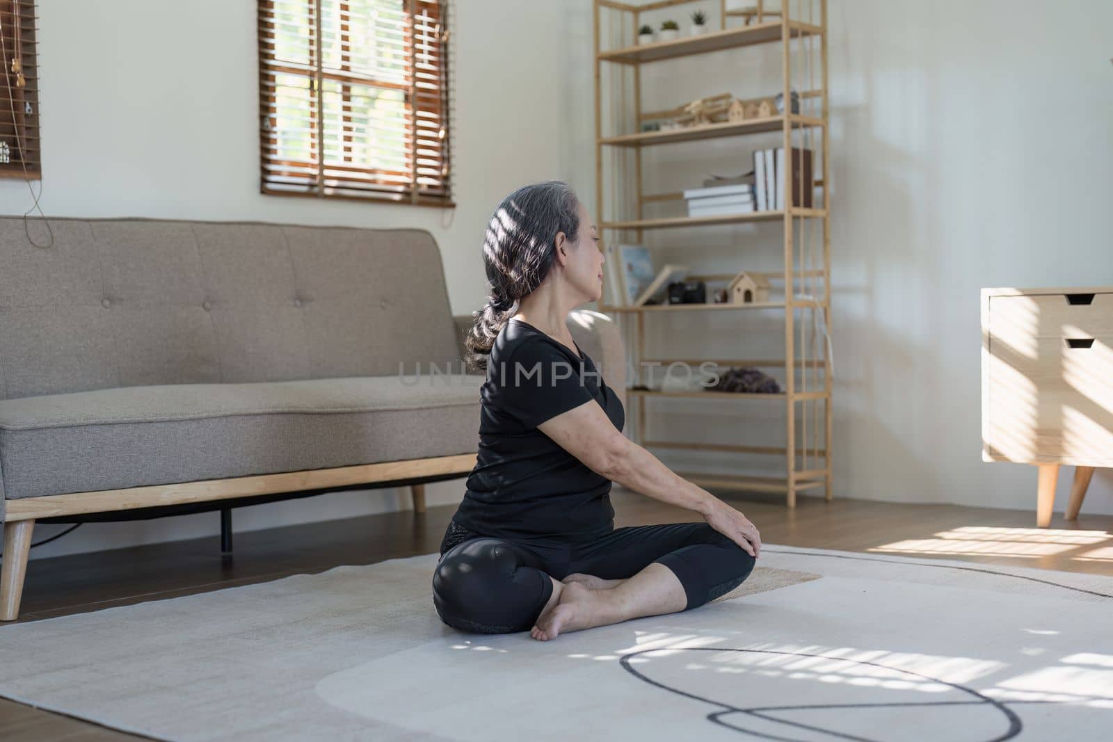 Portrait of Mature Woman doing stretching yoga side bend. exercise and stretching concept by itchaznong