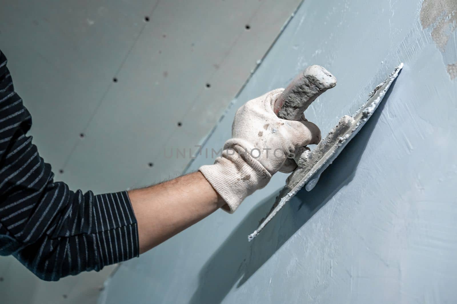 manual work with a trowel for waterproofing the wall.