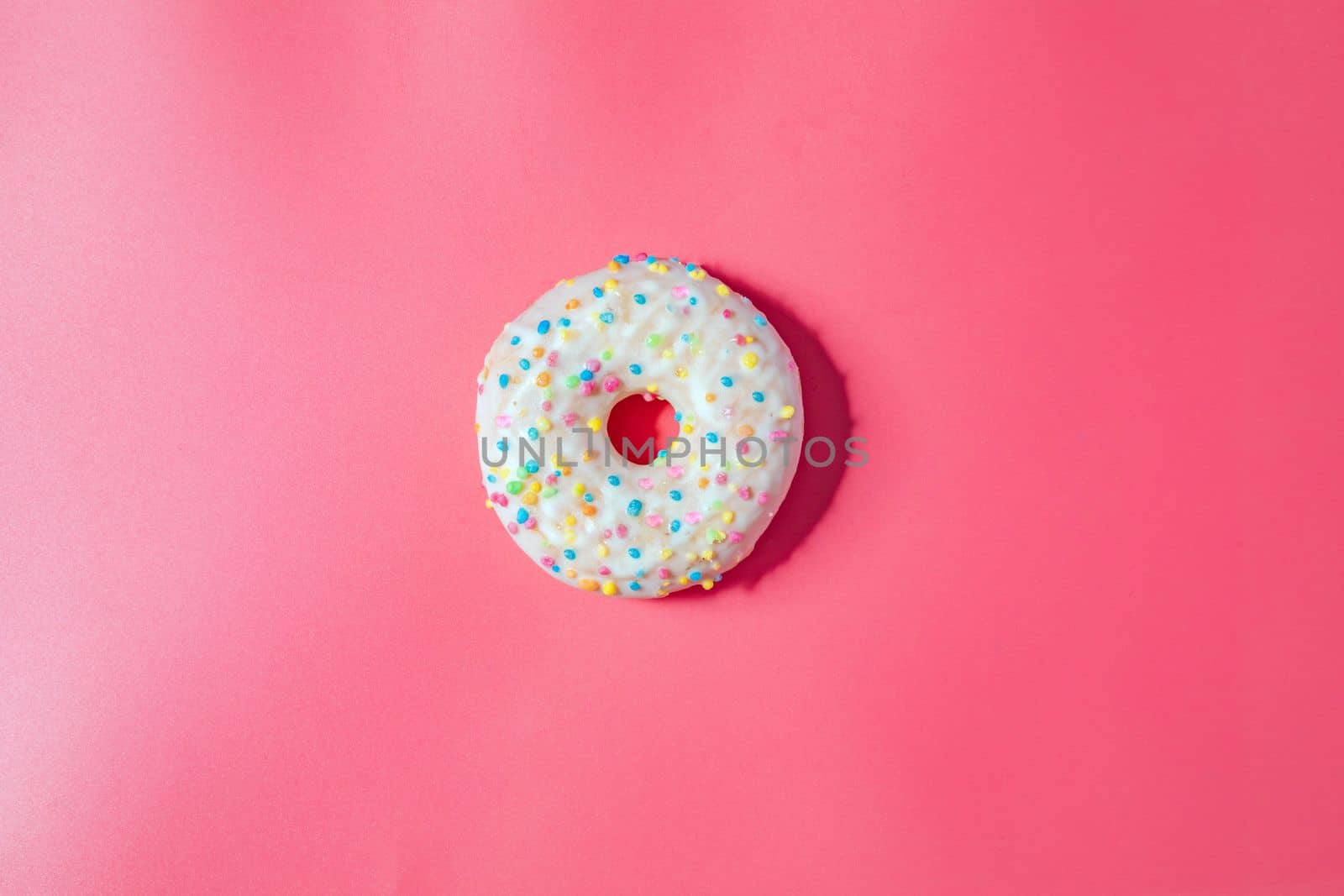 Donuts with icing on pastel pink background. Sweet donuts. top view assorted with various chocolate glazed and sprinkles, sugar sweets concept candy