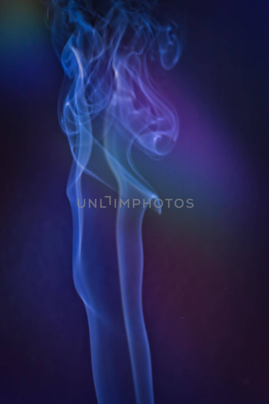 A vertical shot of smoke in colorfull backlight with a blue note