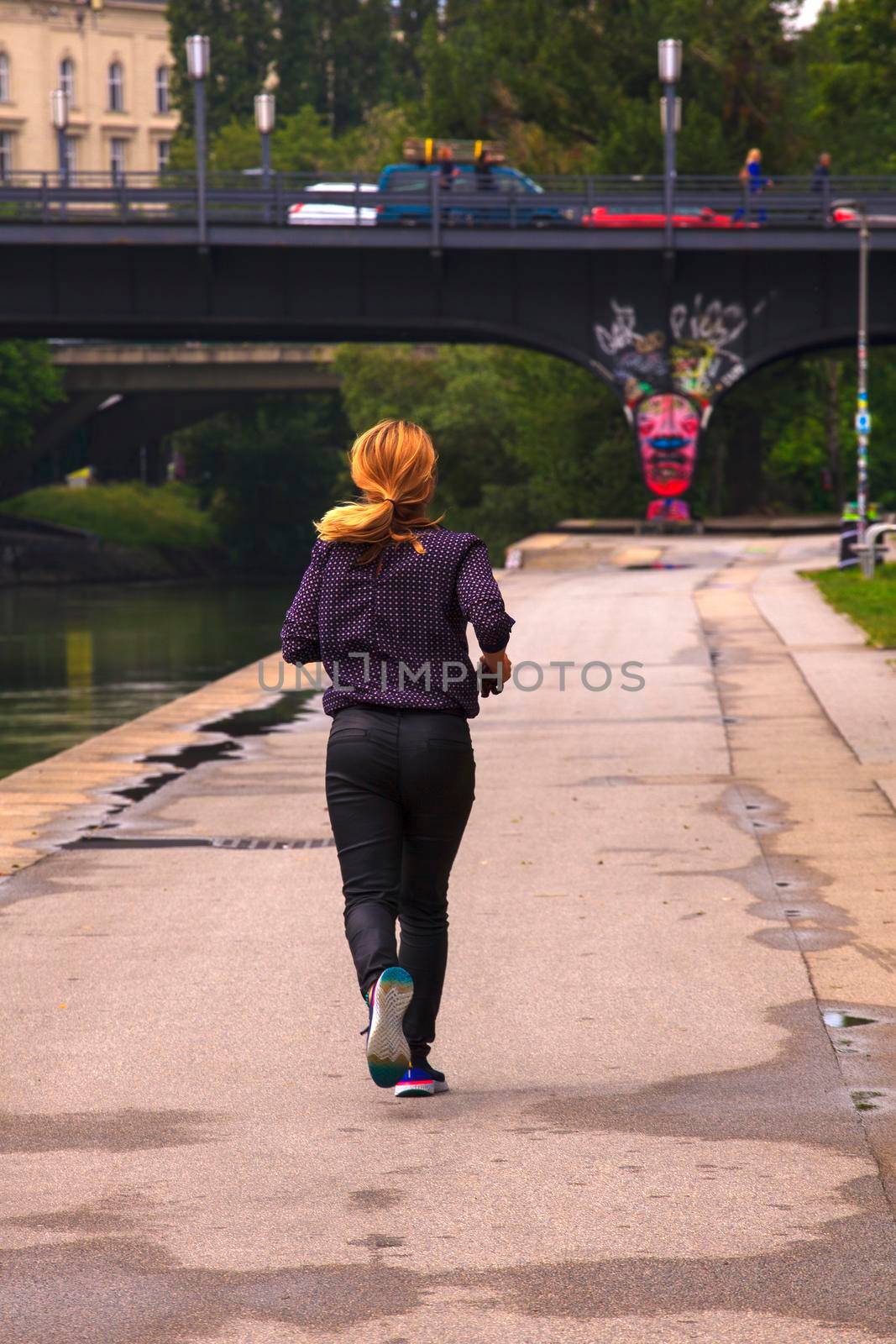 VIENNA, AUSTRIA - MAY, 22: Woman jogging next to the Donaukanal river on May 22, 2018
