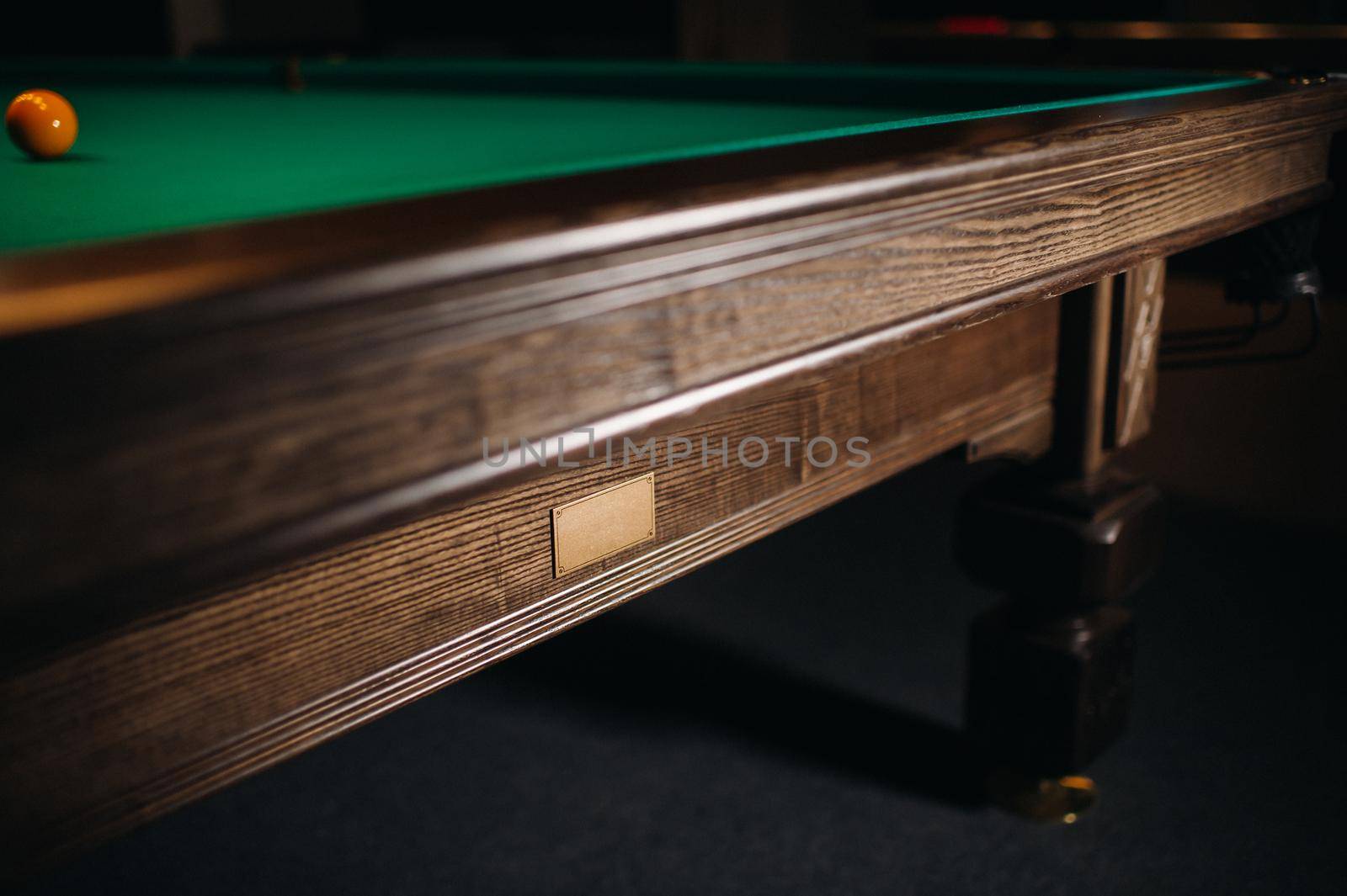 The oak decorative leg of a billiard table looks expensive.