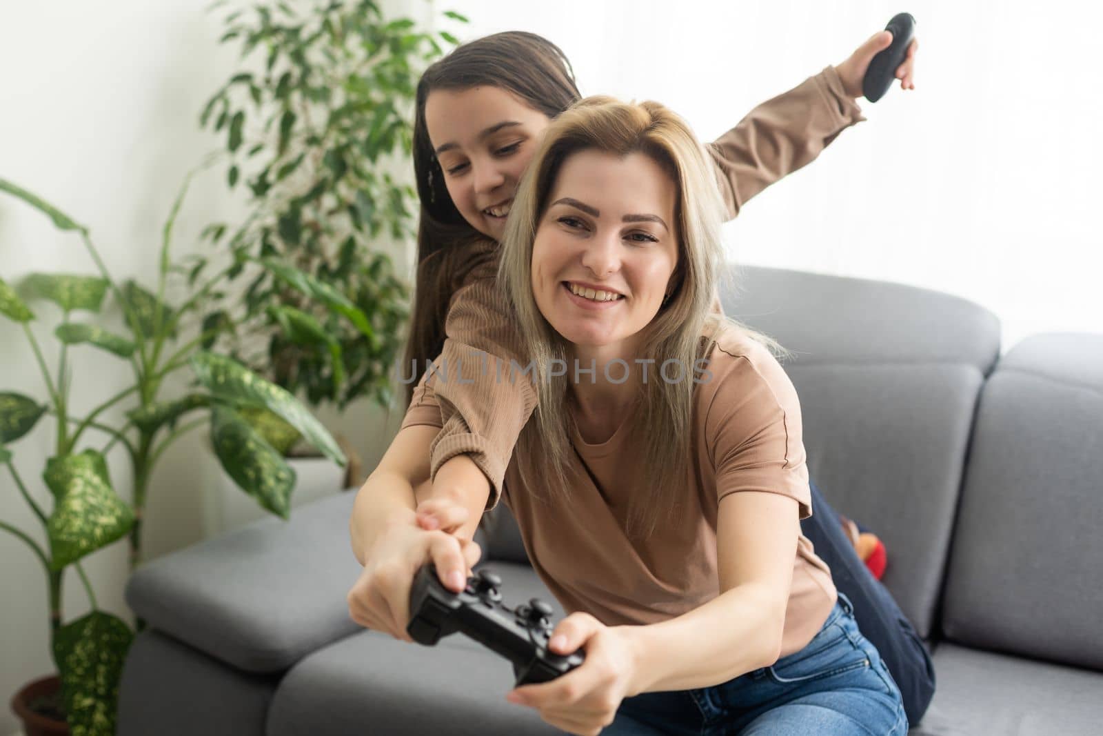 Mother and daughter playing video games on laptop at home