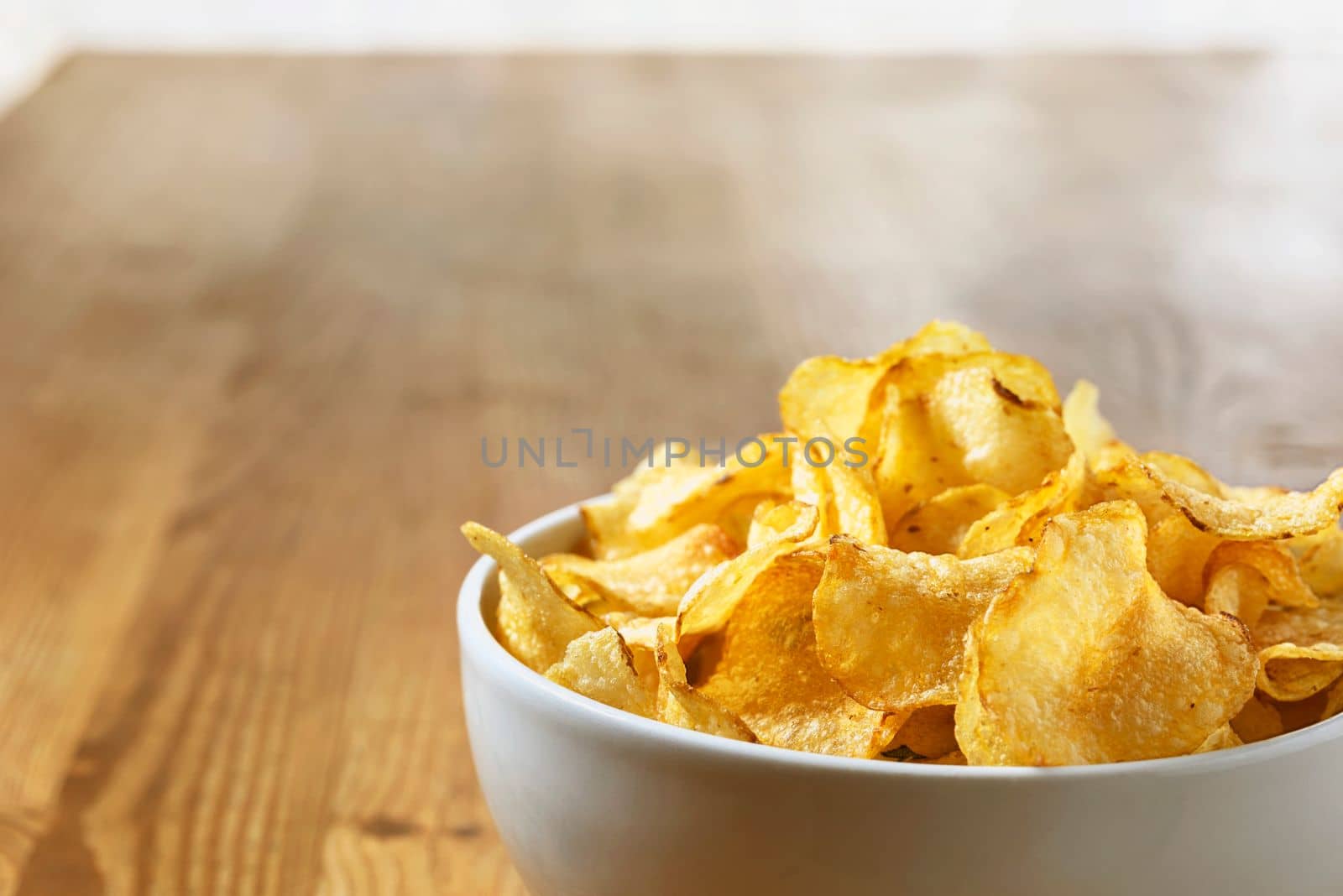 Potato chips  in white bowl on wooden table  ,party time