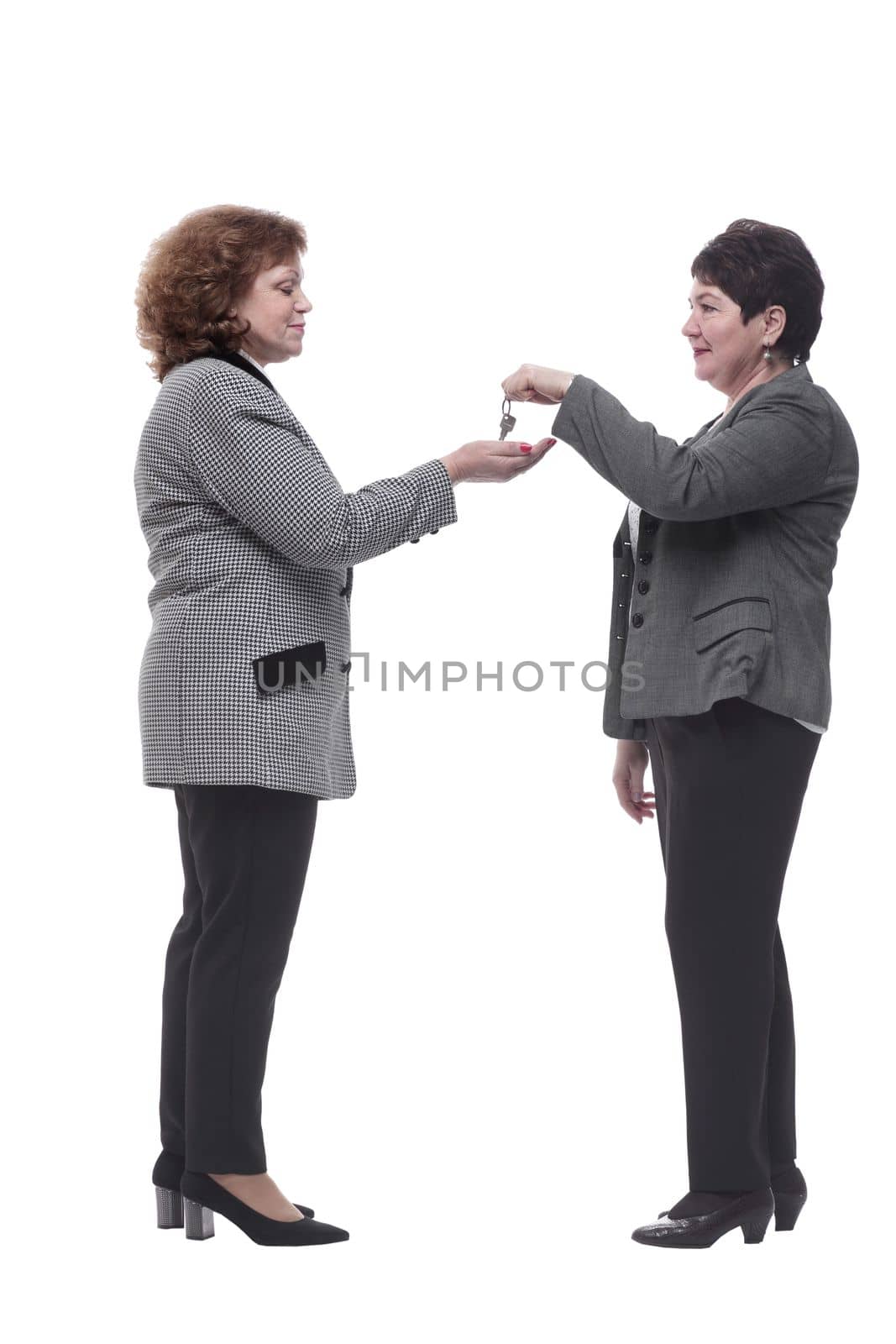 in full growth. real estate agent handing keys to his client . isolated on a white background