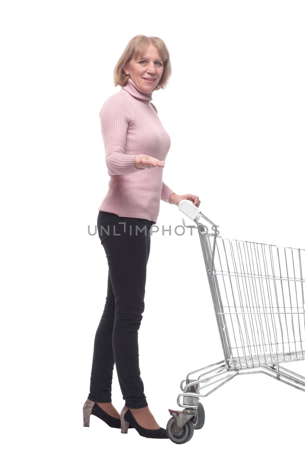 Full length portrait of a woman pushing a shopping trolley isolated on white background