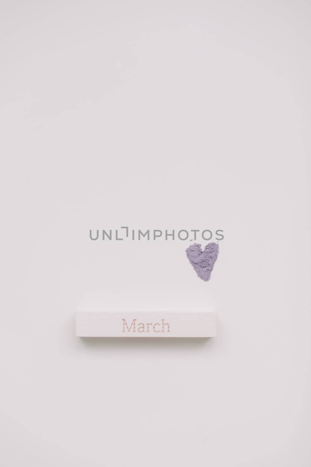 The word March on wooden brick on a white background top view.