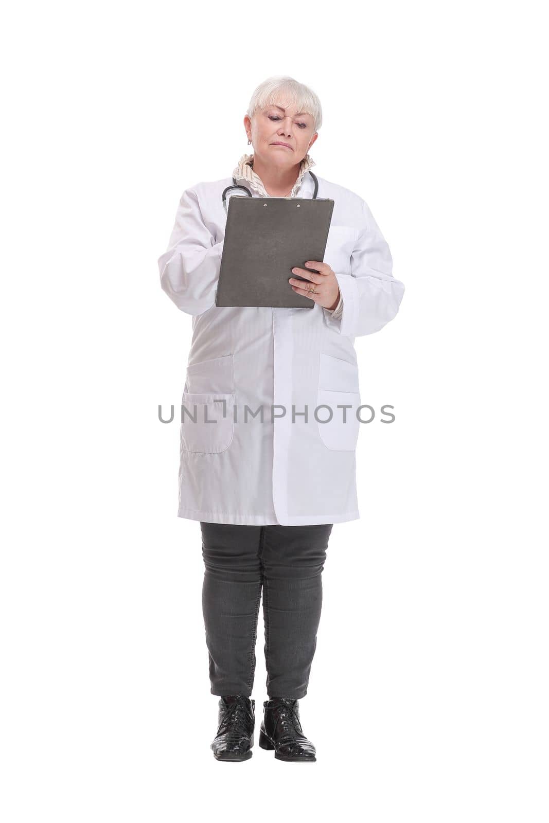 Happy mature doctor with stethoscope writing on clipboard, isolated over white background