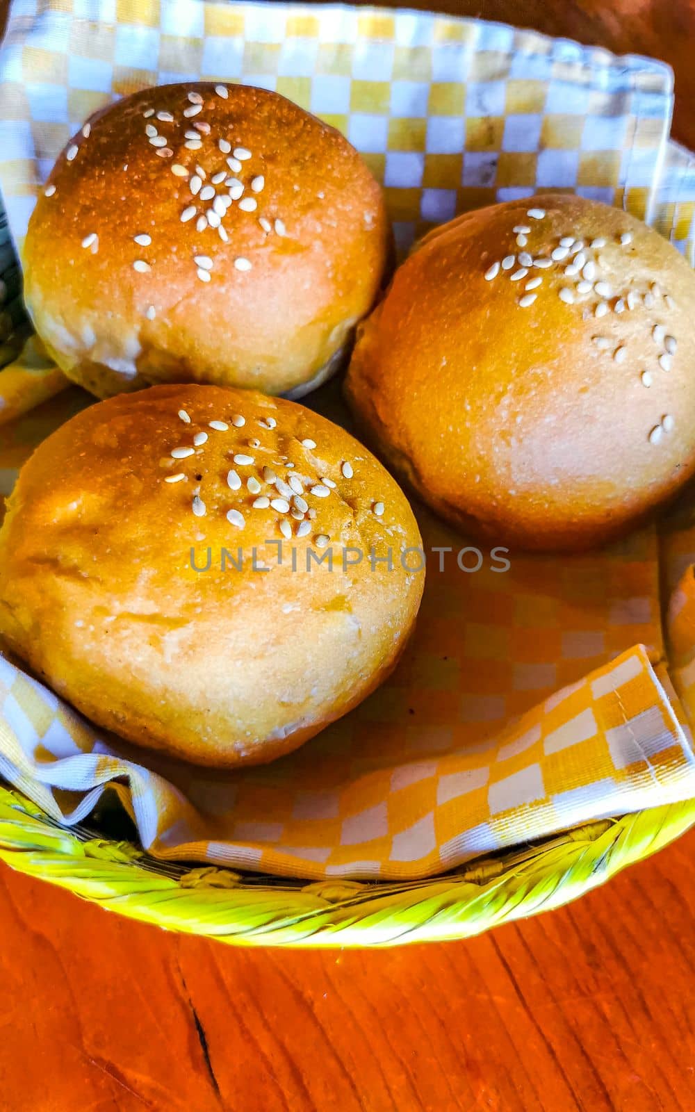 Delicious round buns with sesame seeds on wooden table Mexico. by Arkadij
