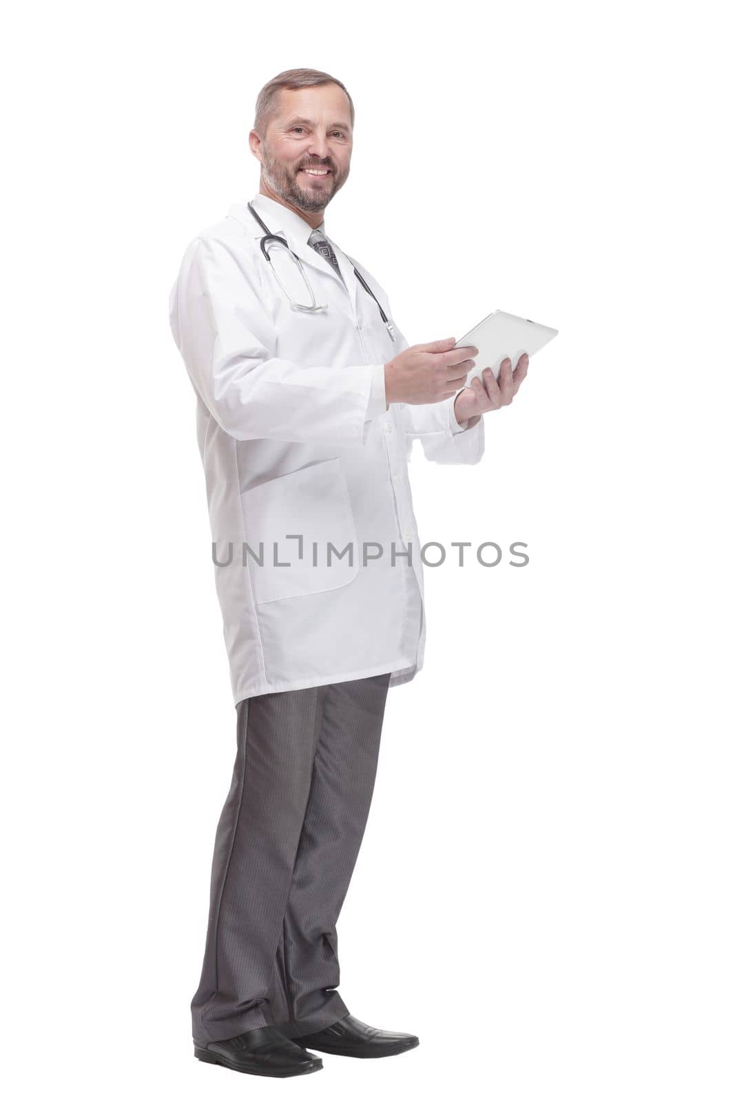 in full growth. smiling doctor with a digital tablet . isolated on a white background.