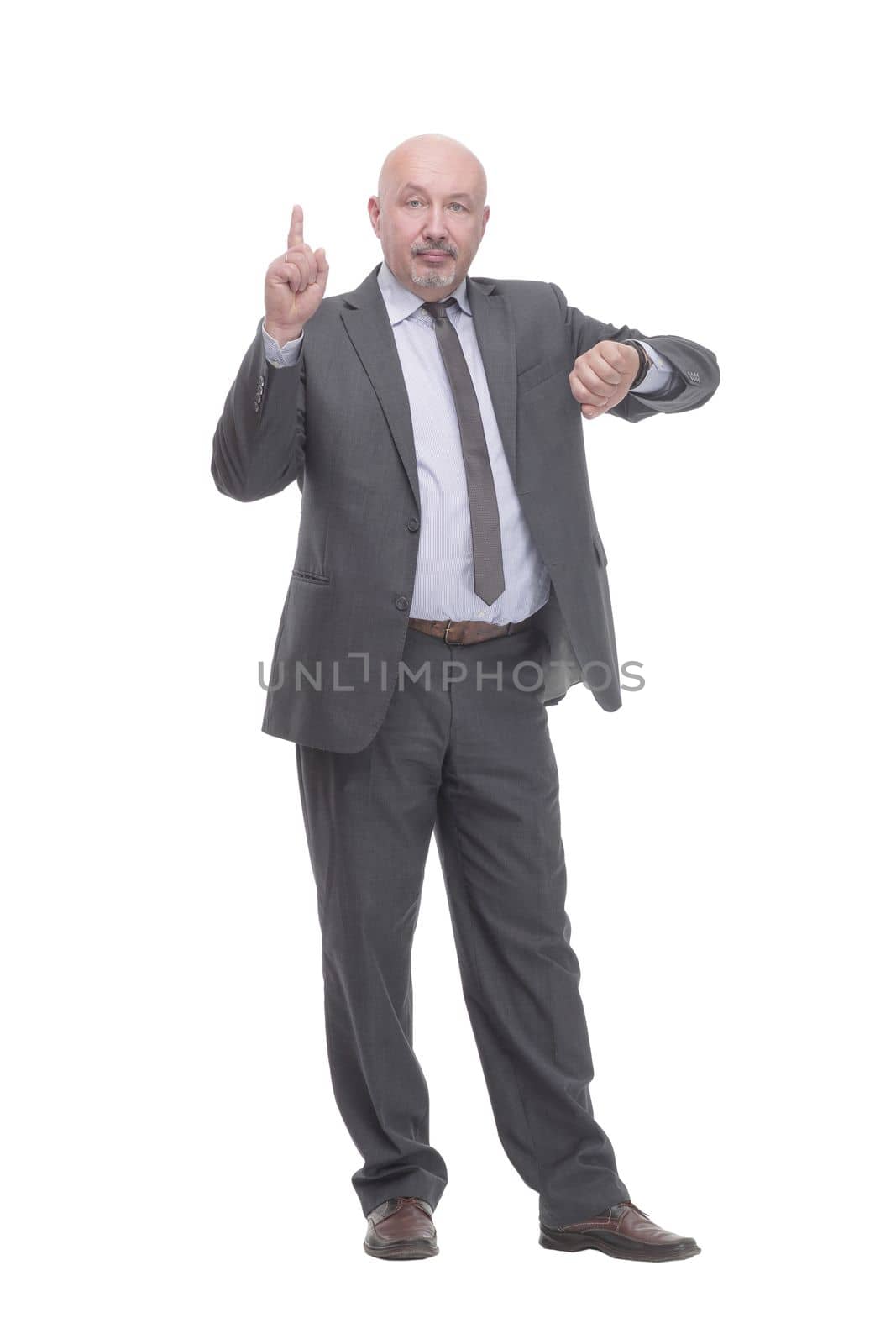 in full growth. business man looking at his wrist watch.isolated on a white background.