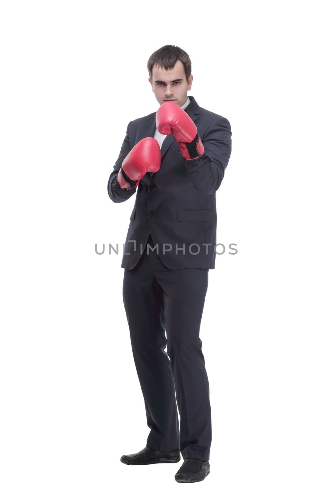 Full length portrait of a young businessman in suit with red boxing gloves posing isolated on white background