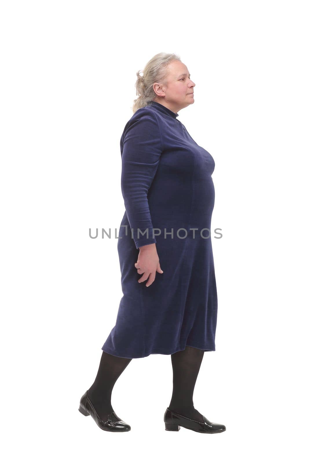 Side view full length profile shot of an elderly woman walking isolated on white background and looking forward