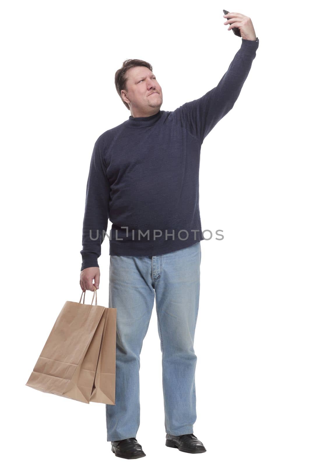 in full growth. casual man with a smartphone .isolated on a white background.