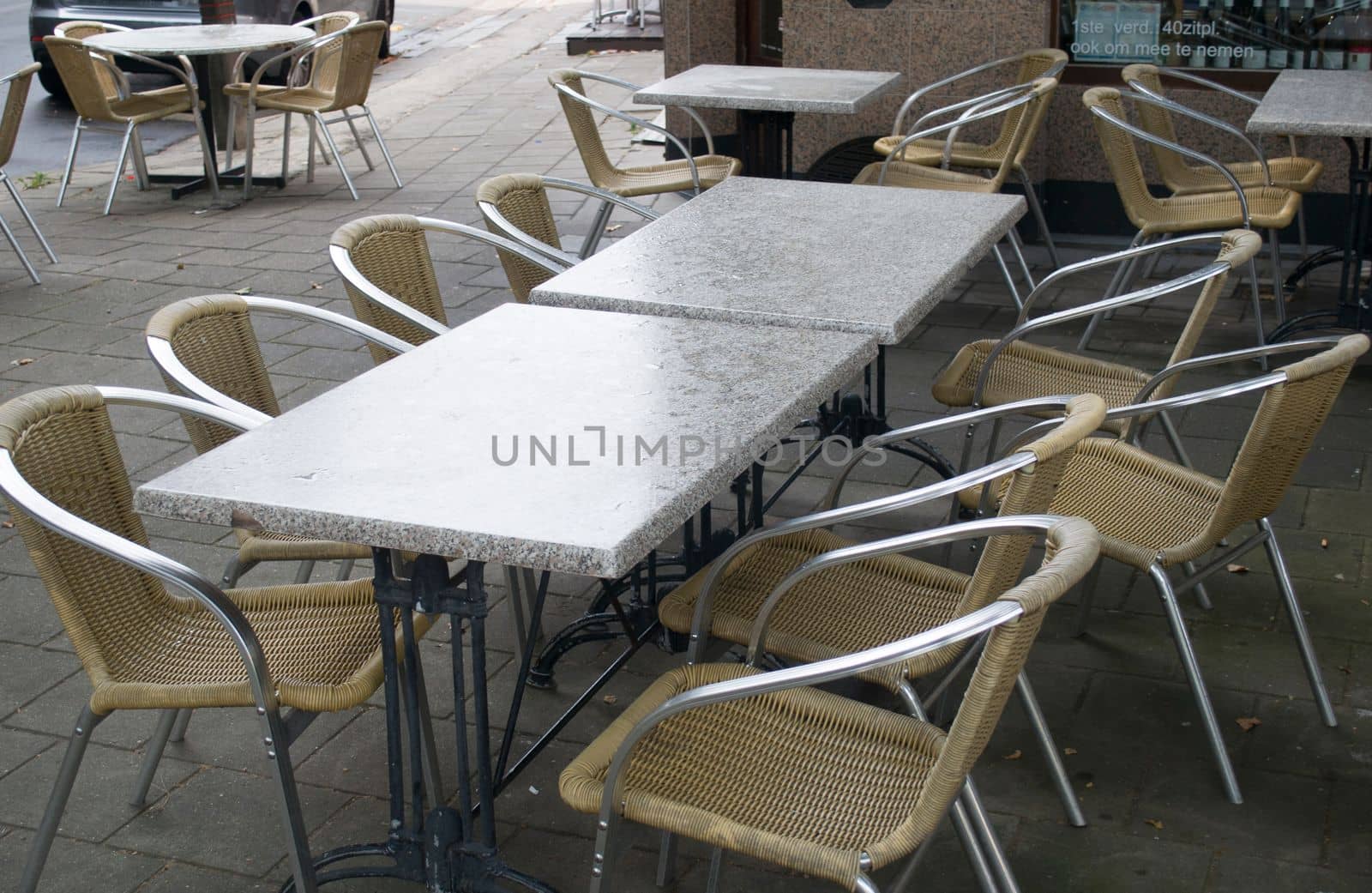 empty tables in an outdoor cafe in Antwerp wet seats and tables after a rainstorm. High quality photo