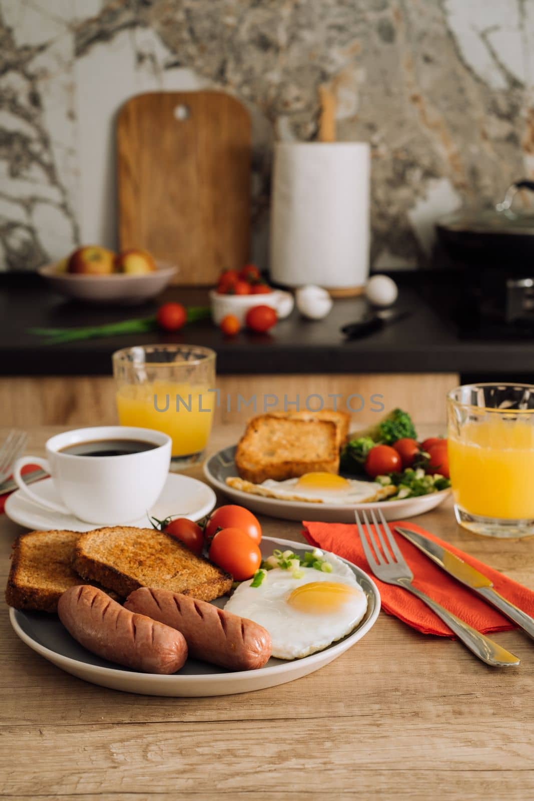 Home cooked English breakfast with cup of black coffee and orange juice in the kitchen by Romvy