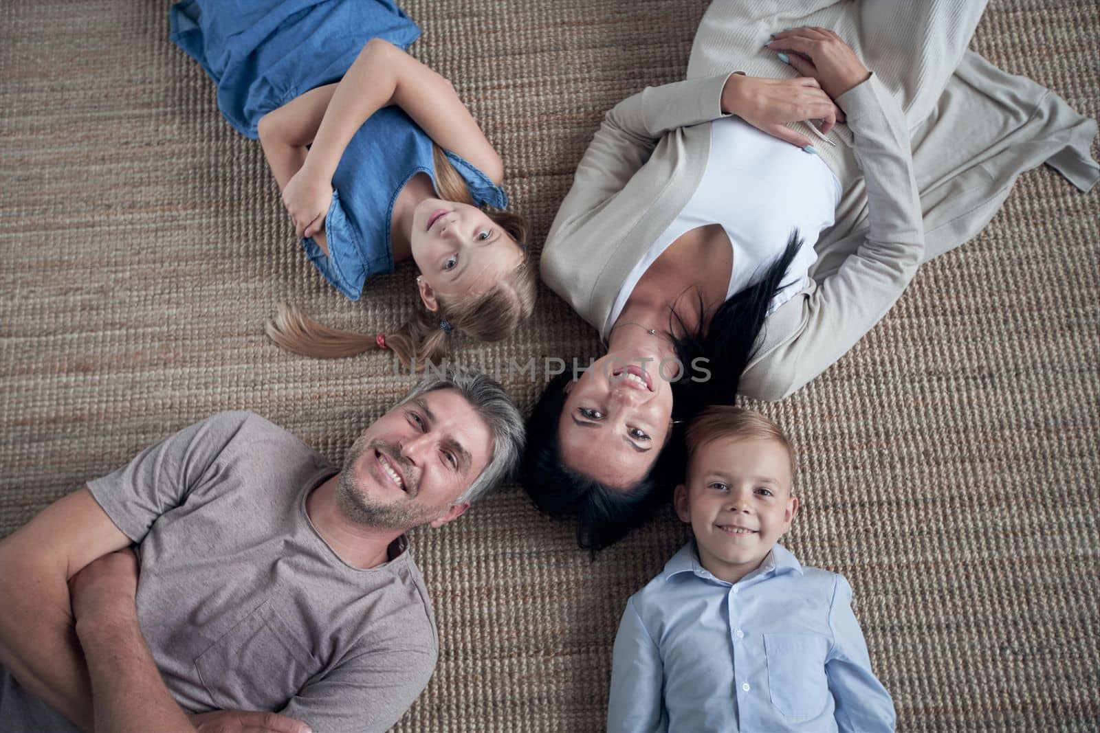 Top view portrait of happy family with kids, lying on the floor