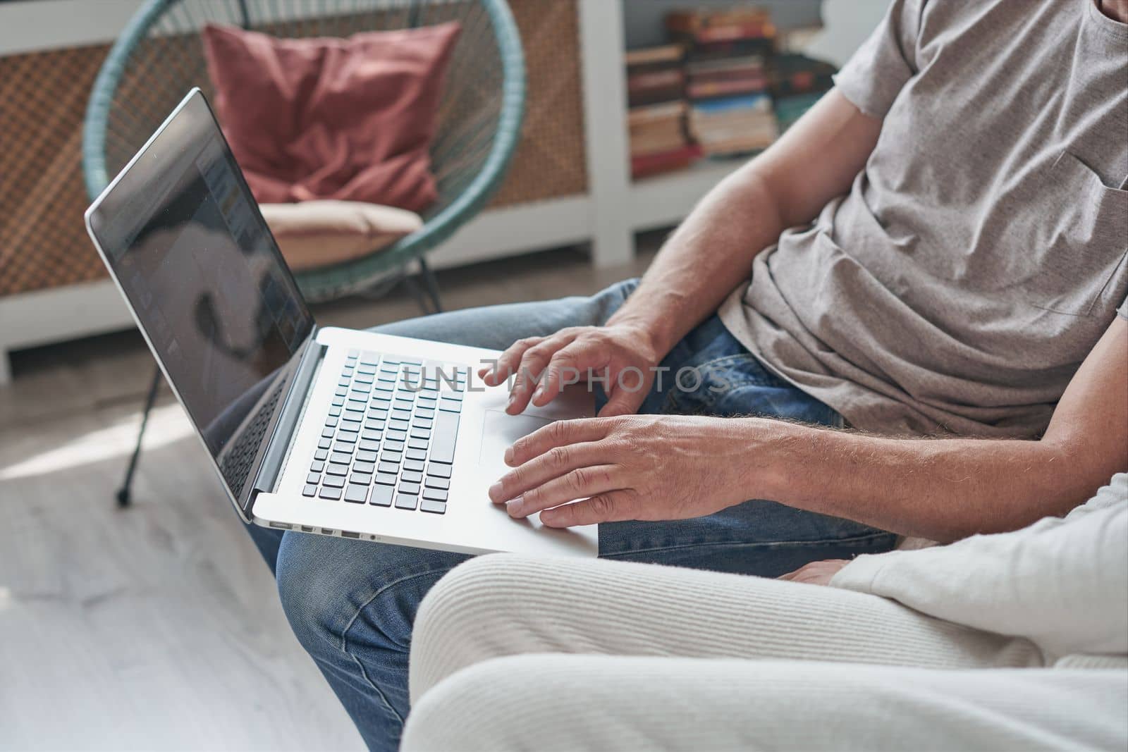 Young man using laptop and smiling at home by asdf