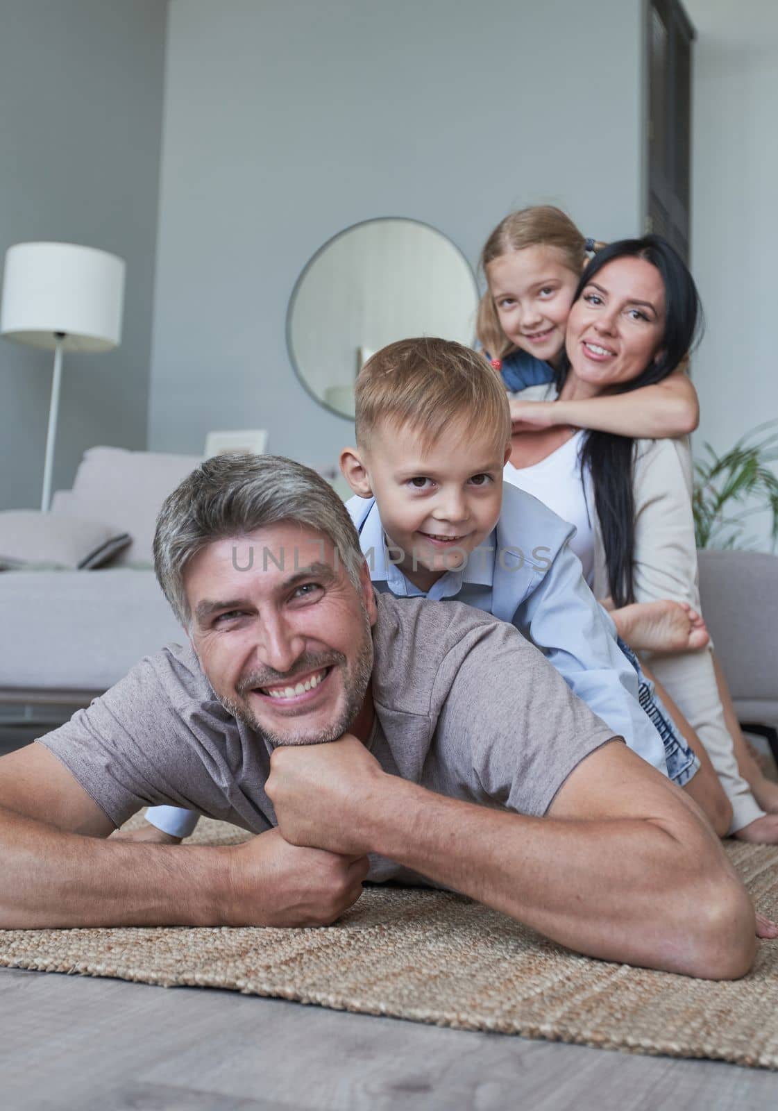 Young family of four having fun at home smiling