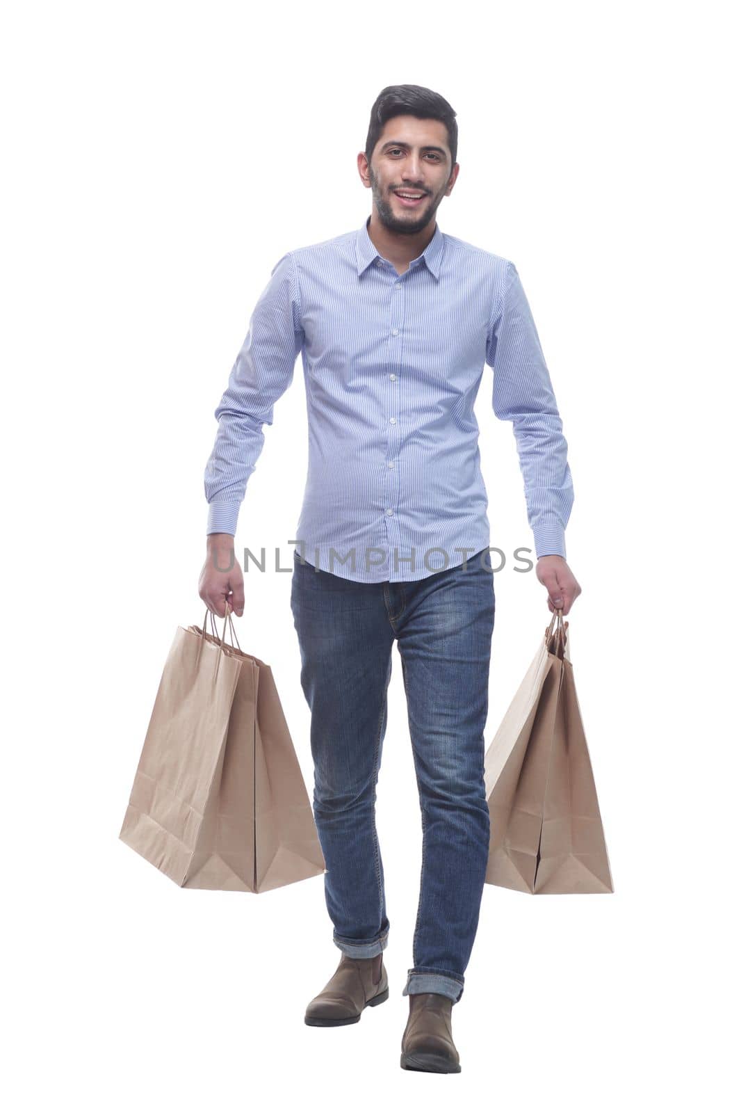 in full growth. young man with shopping bags striding forward. isolated on a white background.