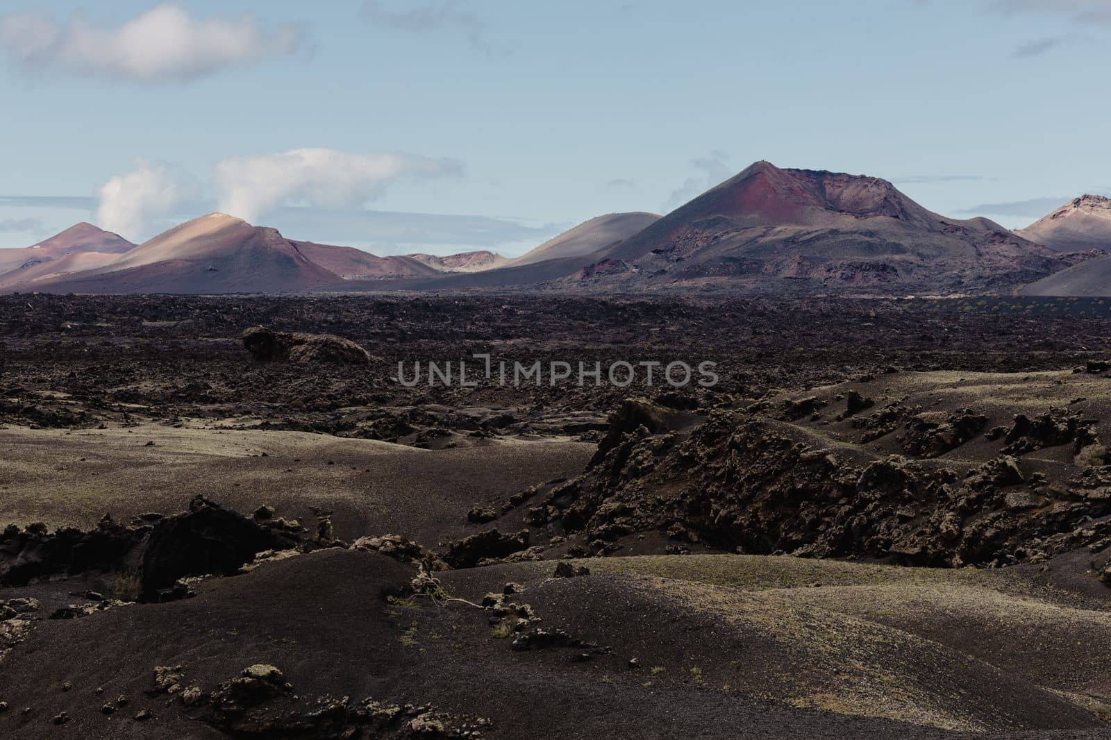 Black volcanic landscape of Timanfaya National Park in Lanzarote. Popular touristic attraction in Lanzarote island, Canary Islands, Spain. by kasto