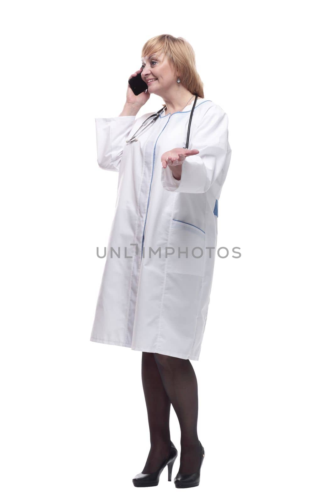in full growth.Mature female doctor with smartphone . isolated on a white background.