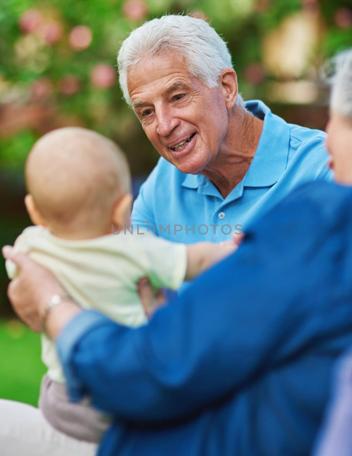 Always make time for the things that make you happy. a senior couple spending time with their grandson. by YuriArcurs