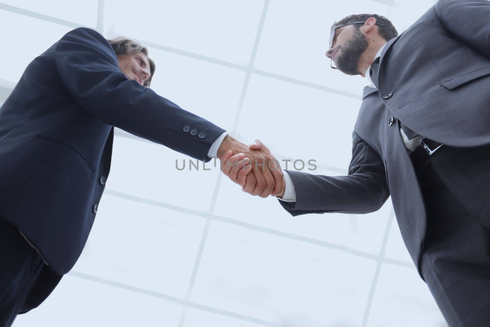 bottom view of two men shaking hands while standing by asdf