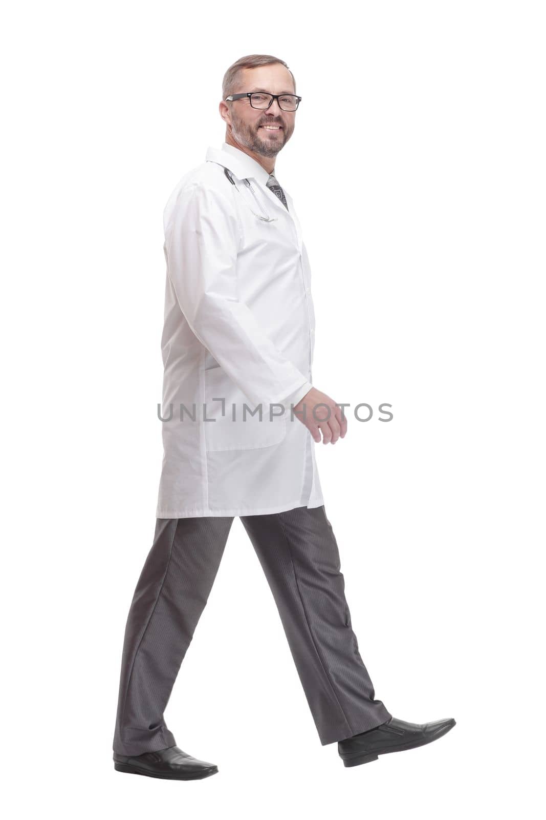 full-length. Mature male doctor striding forward. isolated on a white background.