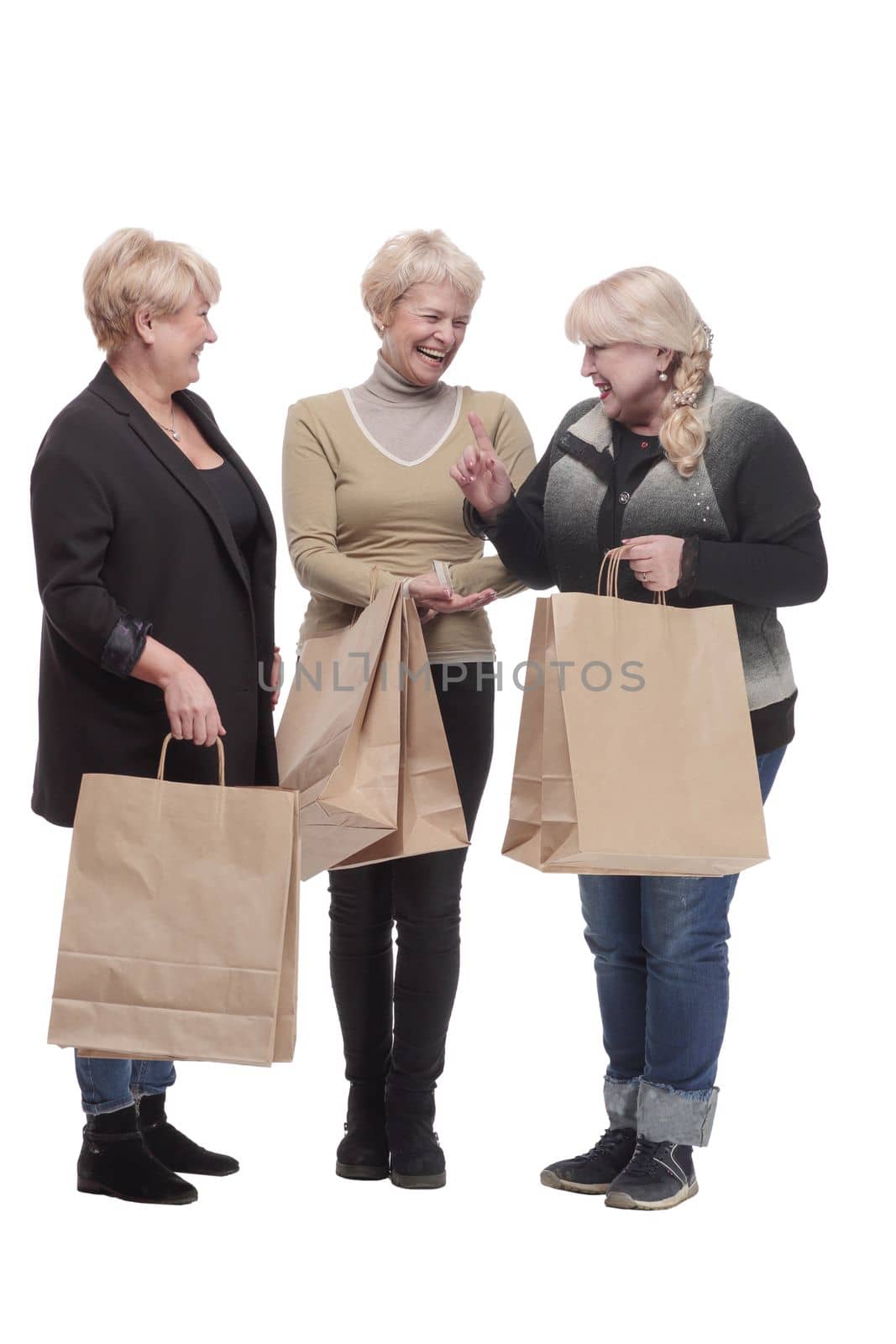 in full growth. three happy women with shopping bags. isolated on a white background.