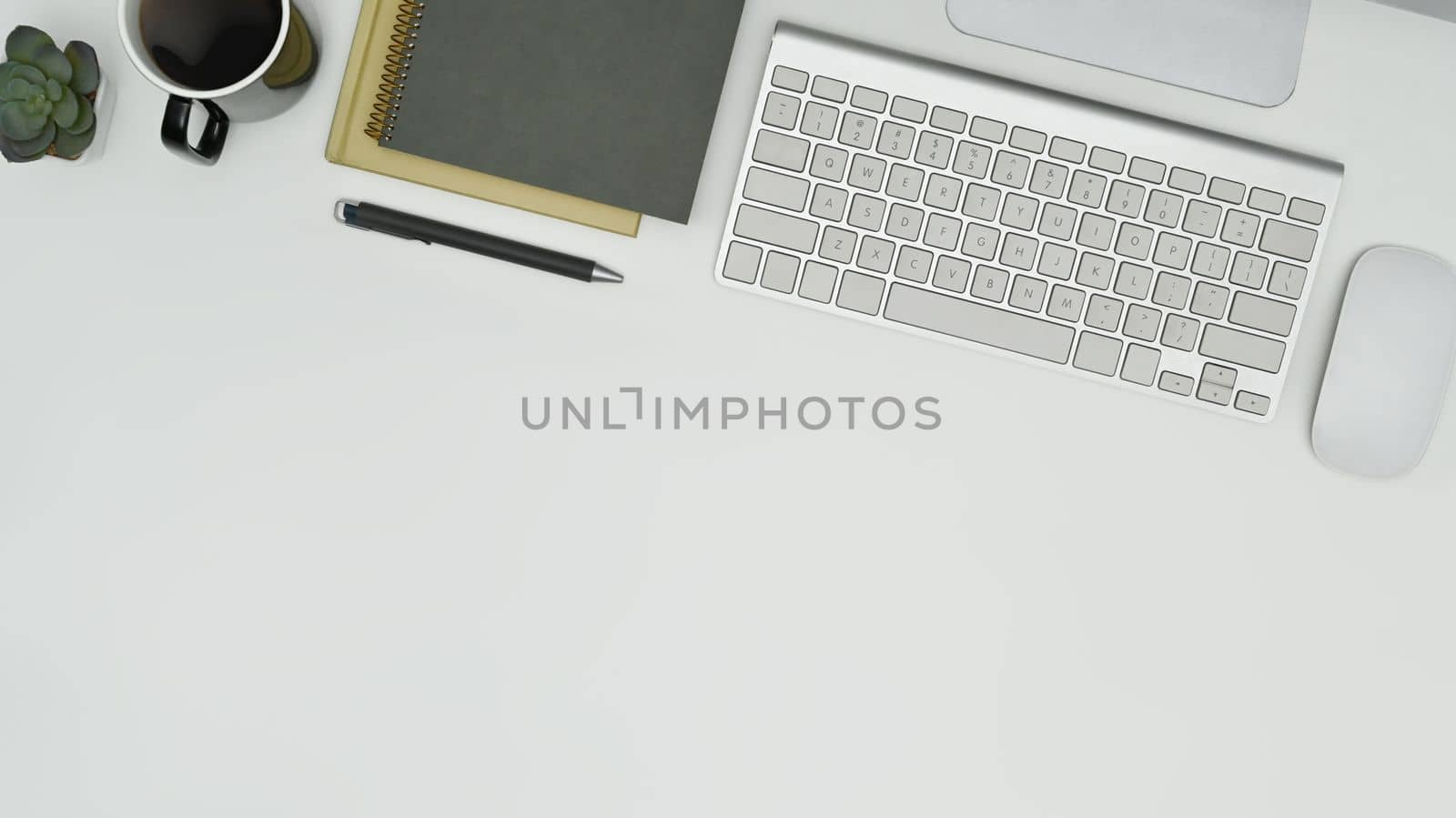 Top view of notepad, cup of coffee, wireless keyboard and mouse on white table. Copy space for your text.