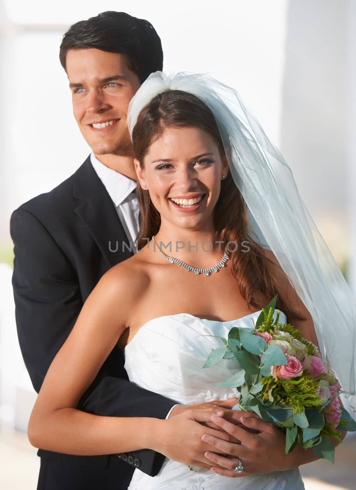 The greatest day of their lives. Two newlyweds posing outdoors happily