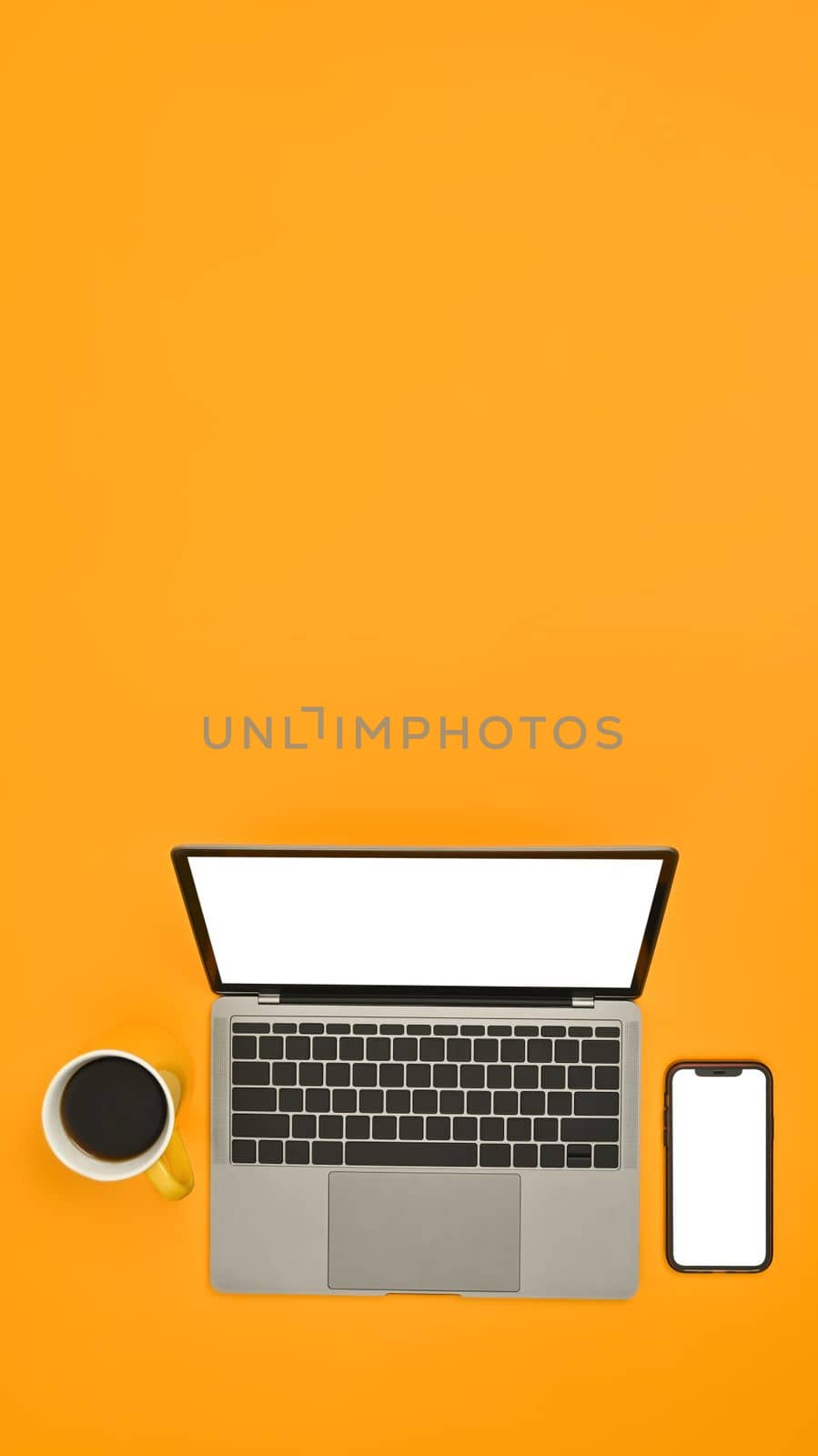 Mock up laptop and smart phone with empty screens on yellow background. Copy space for text information or content by prathanchorruangsak