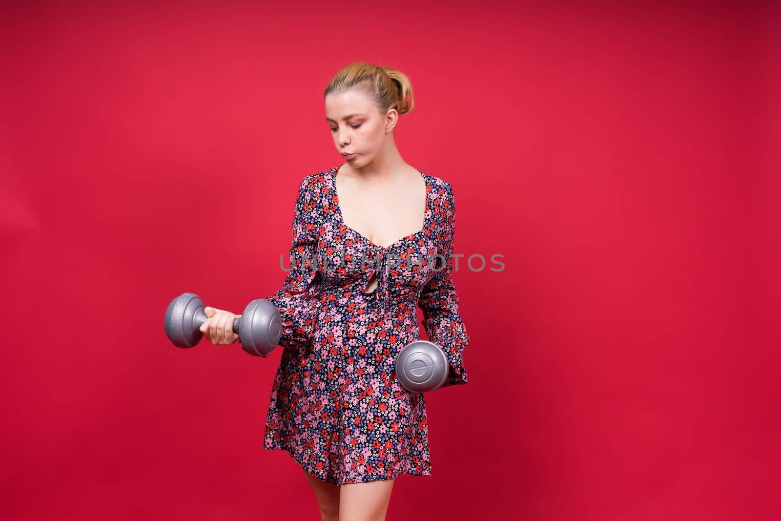 Strong sportswoman in boxing gloves prepared high kick. Isolated on a white, red, yellow background