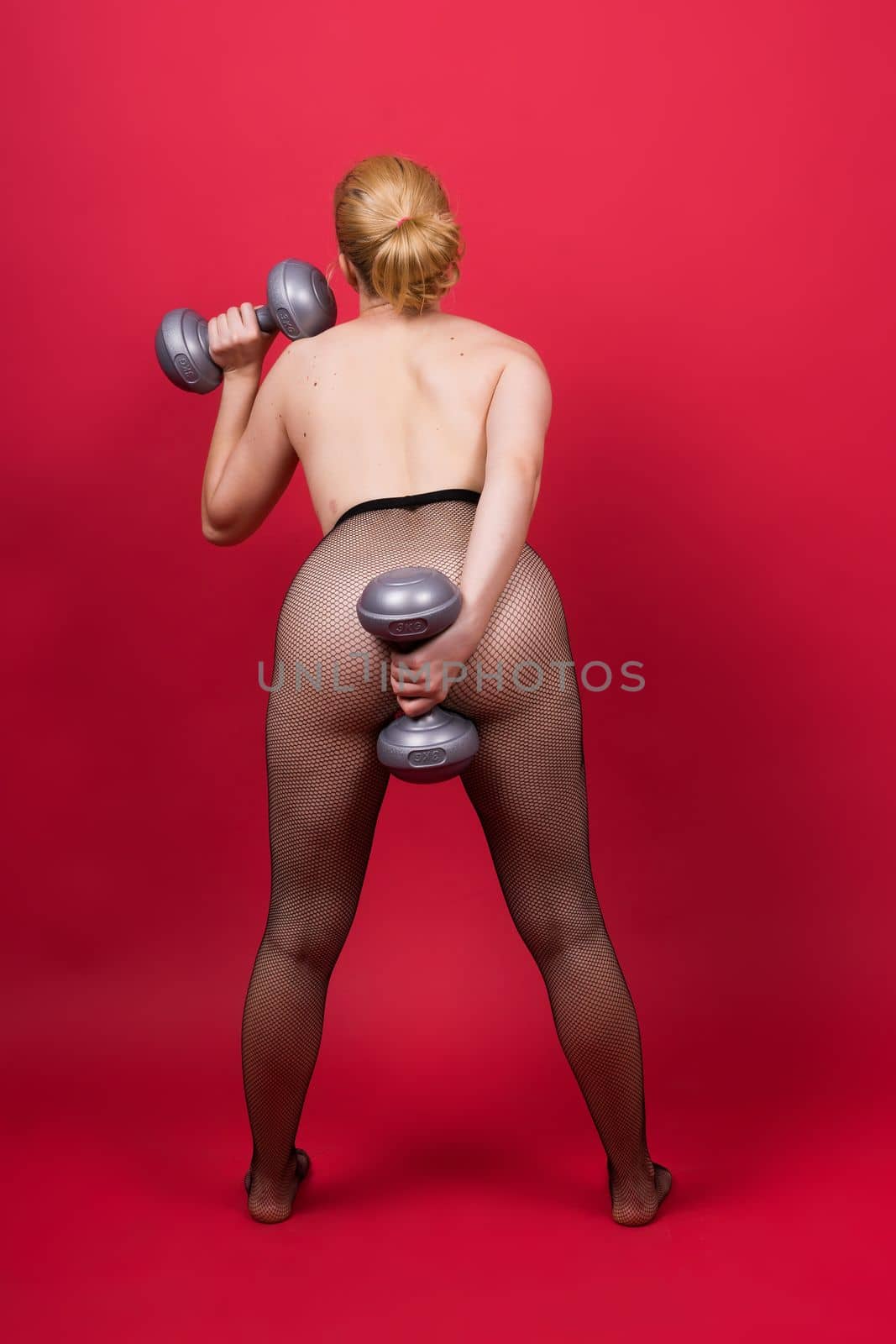 Strong sportswoman in boxing gloves prepared high kick. Isolated on white, red, yellow background by Zelenin
