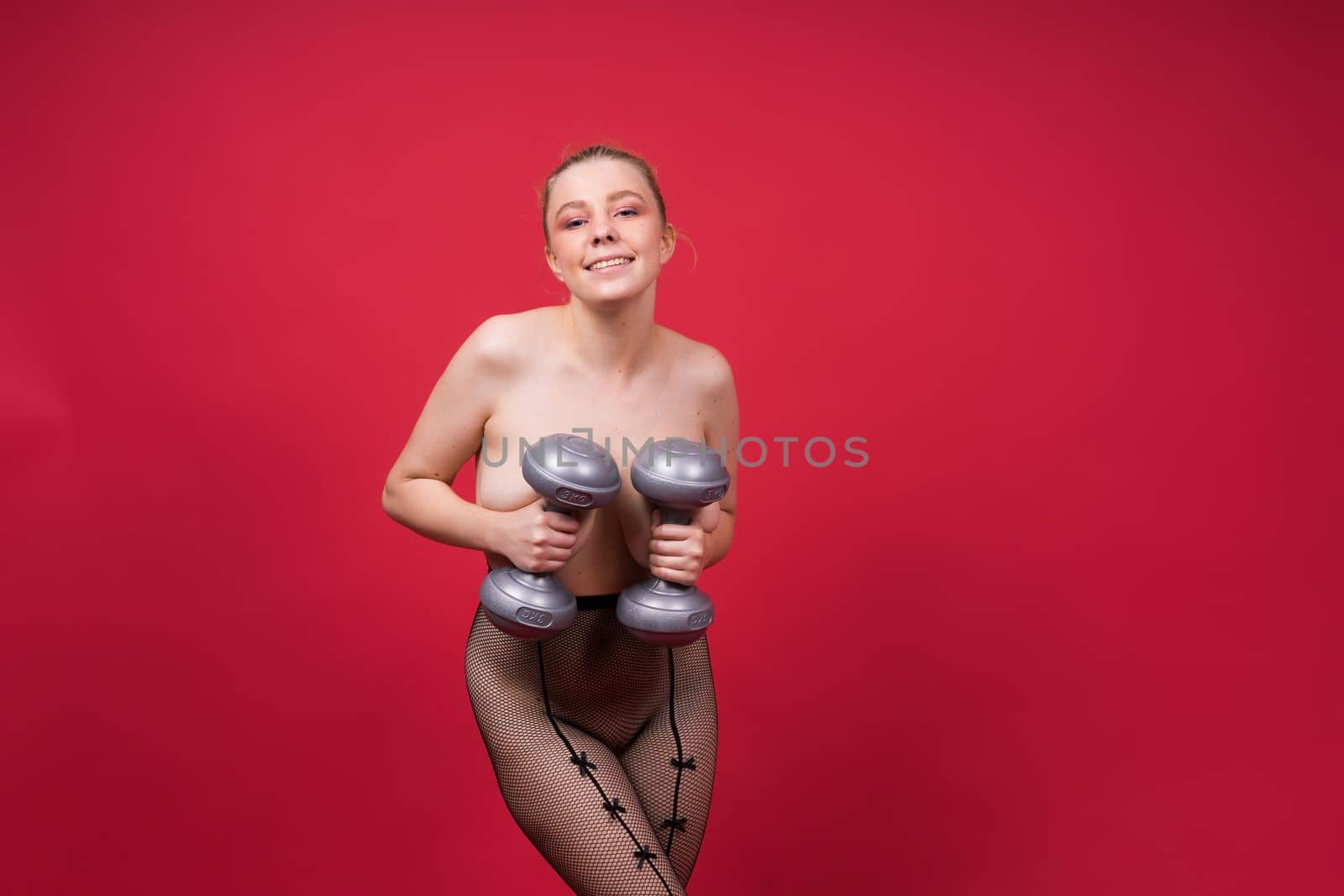 Strong sportswoman in boxing gloves prepared high kick. Isolated on a white, red, yellow background