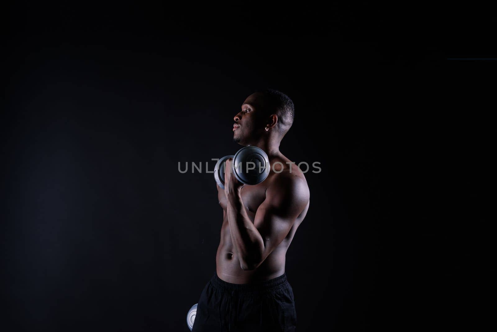 Portrait of a happy african man with dumbbells over red background by Zelenin