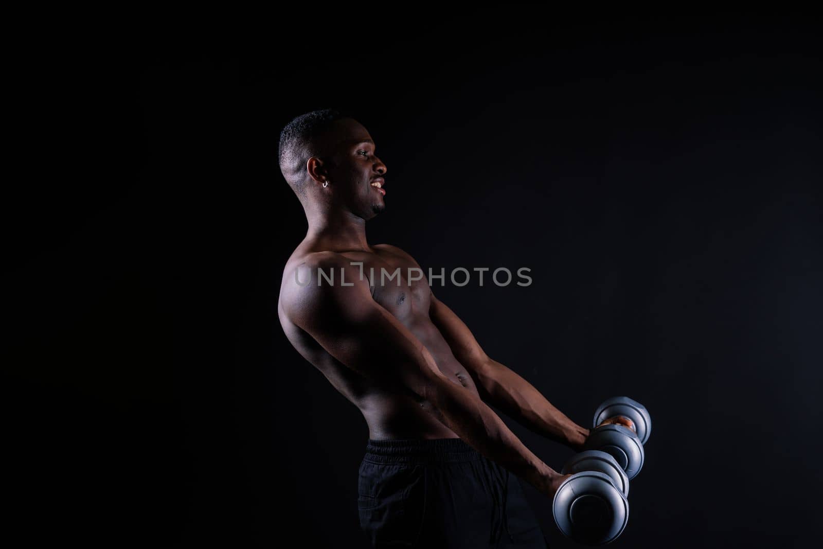 Portrait of happy african man with dumbbells over red background