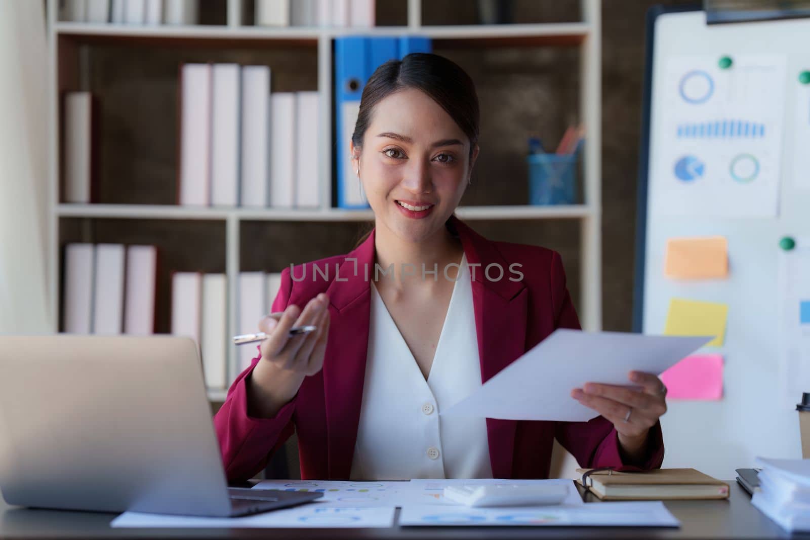 Asian Business woman working at home office and analyze financial report document. Accounting and Finance concept by itchaznong