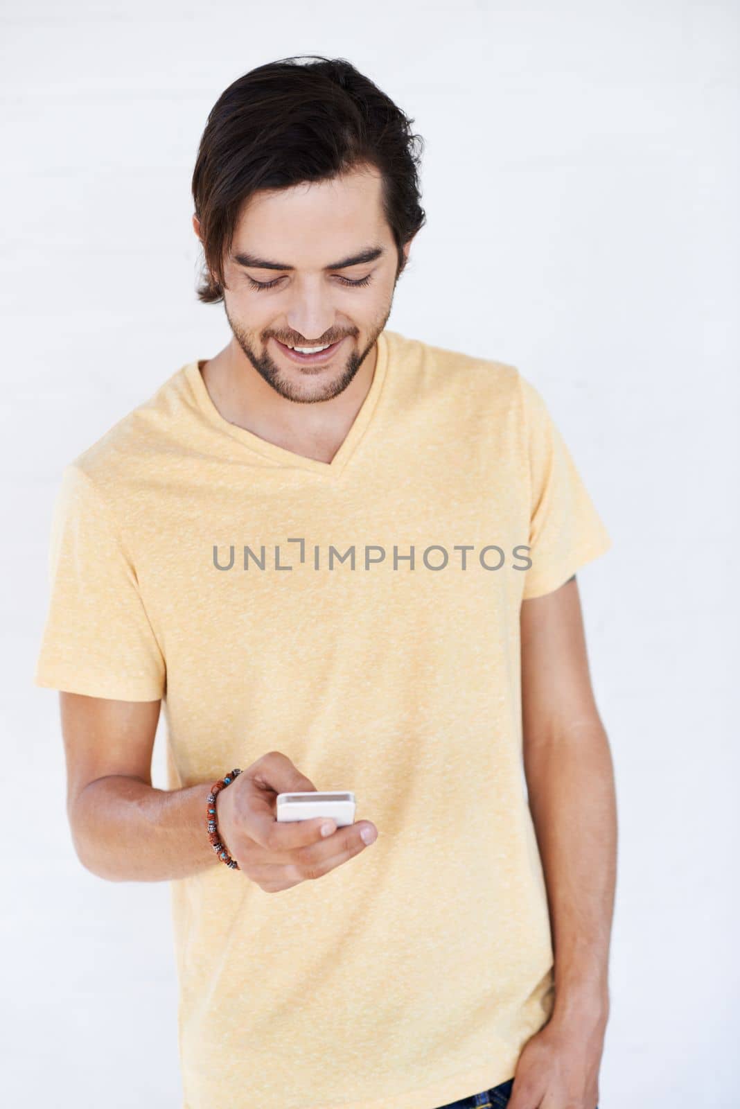 Phone, communication and man on technology typing a cellphone text with isolated white background. Mobile conversation, model and smile of a person with a mobile phone texting with technology.