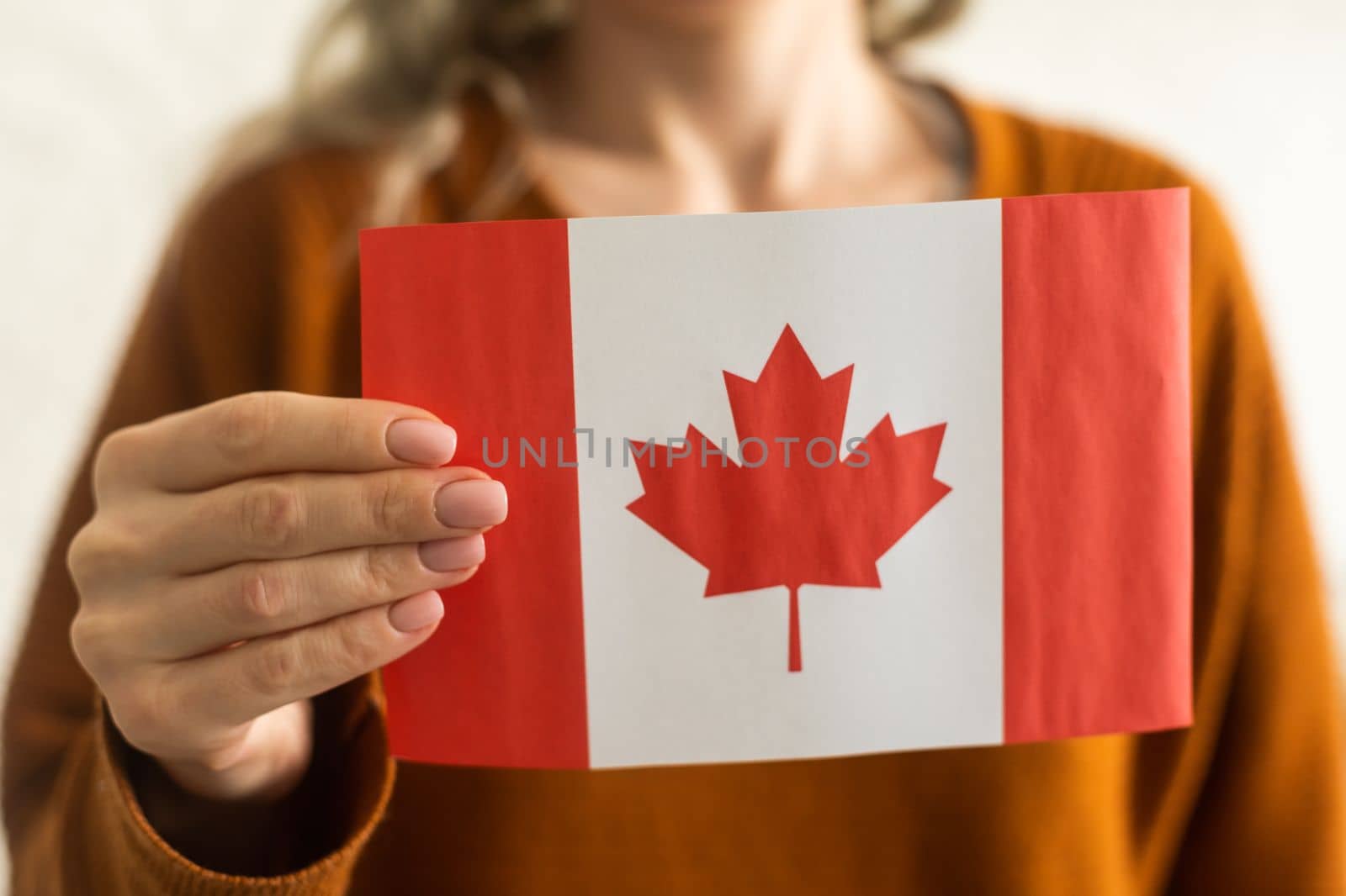 Canadian flag in hands on white.