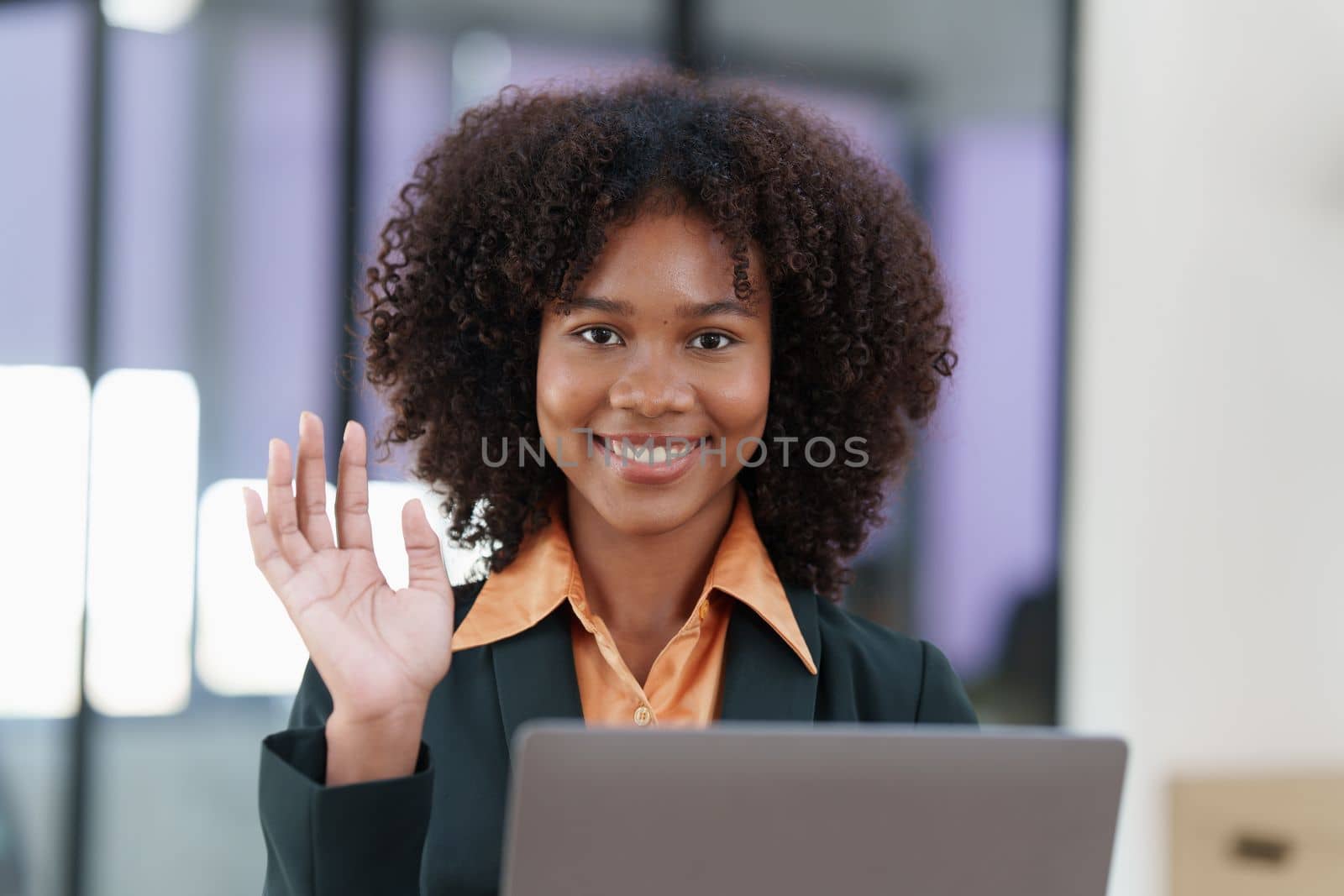 Beautiful American women smiling and using video call application on laptop.