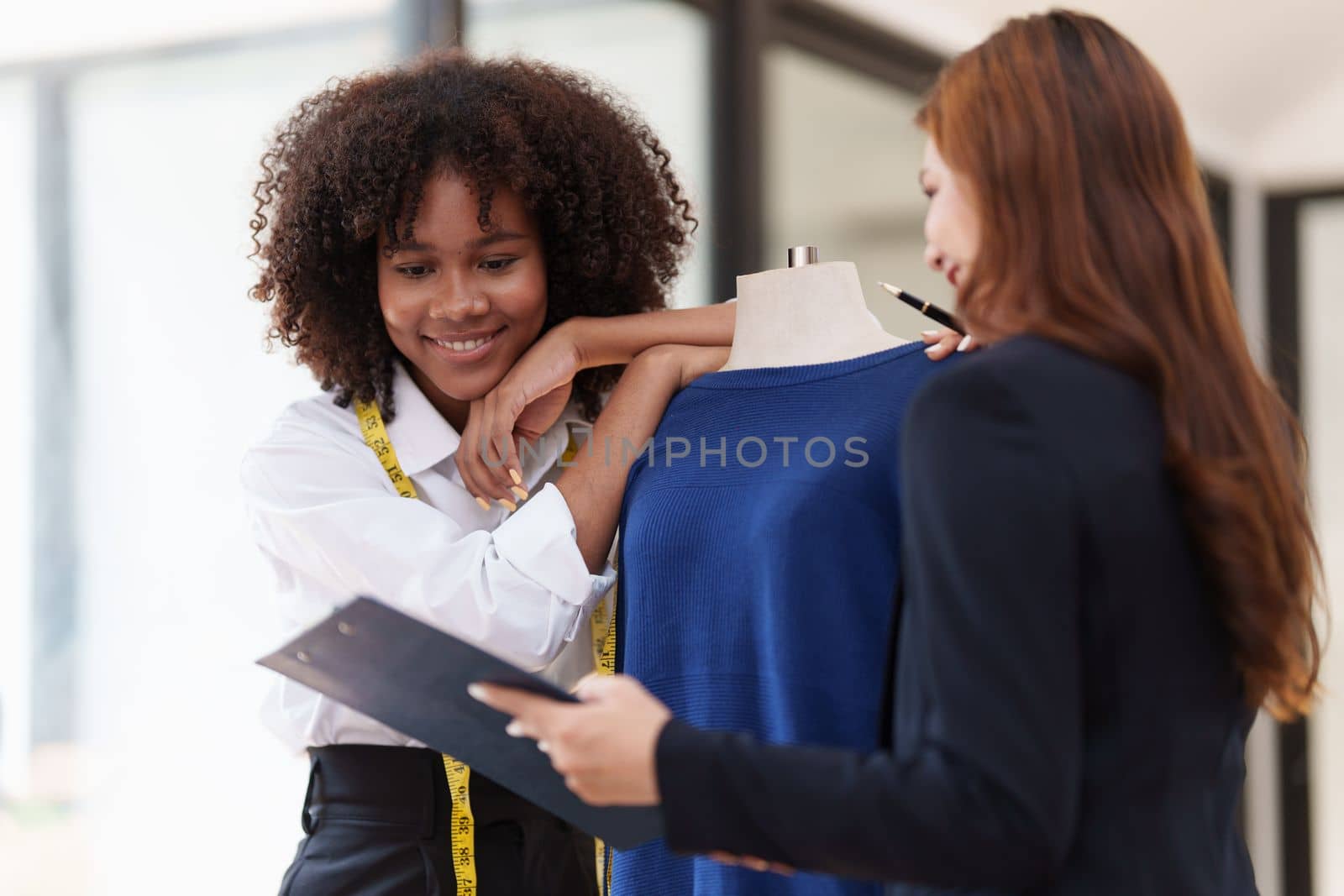 Portrait of young african american woman fashion designer stylish and friend working at fashion studio. by itchaznong