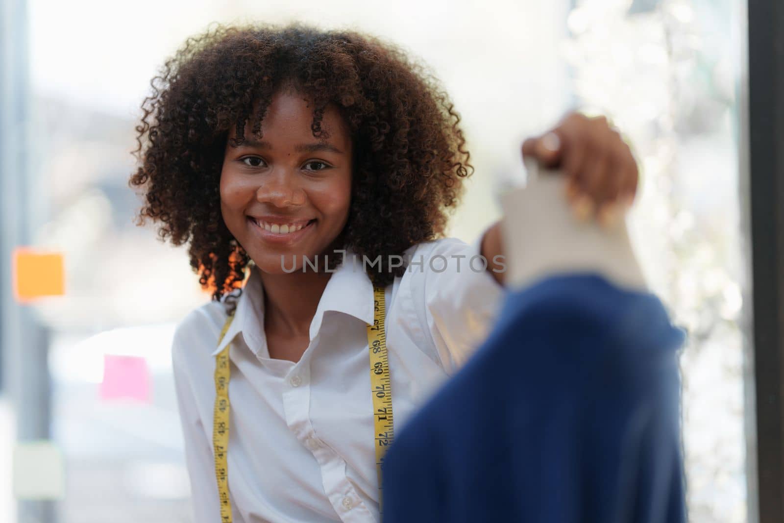 Portrait of young african american woman fashion designer stylish and friend working at fashion studio. by itchaznong