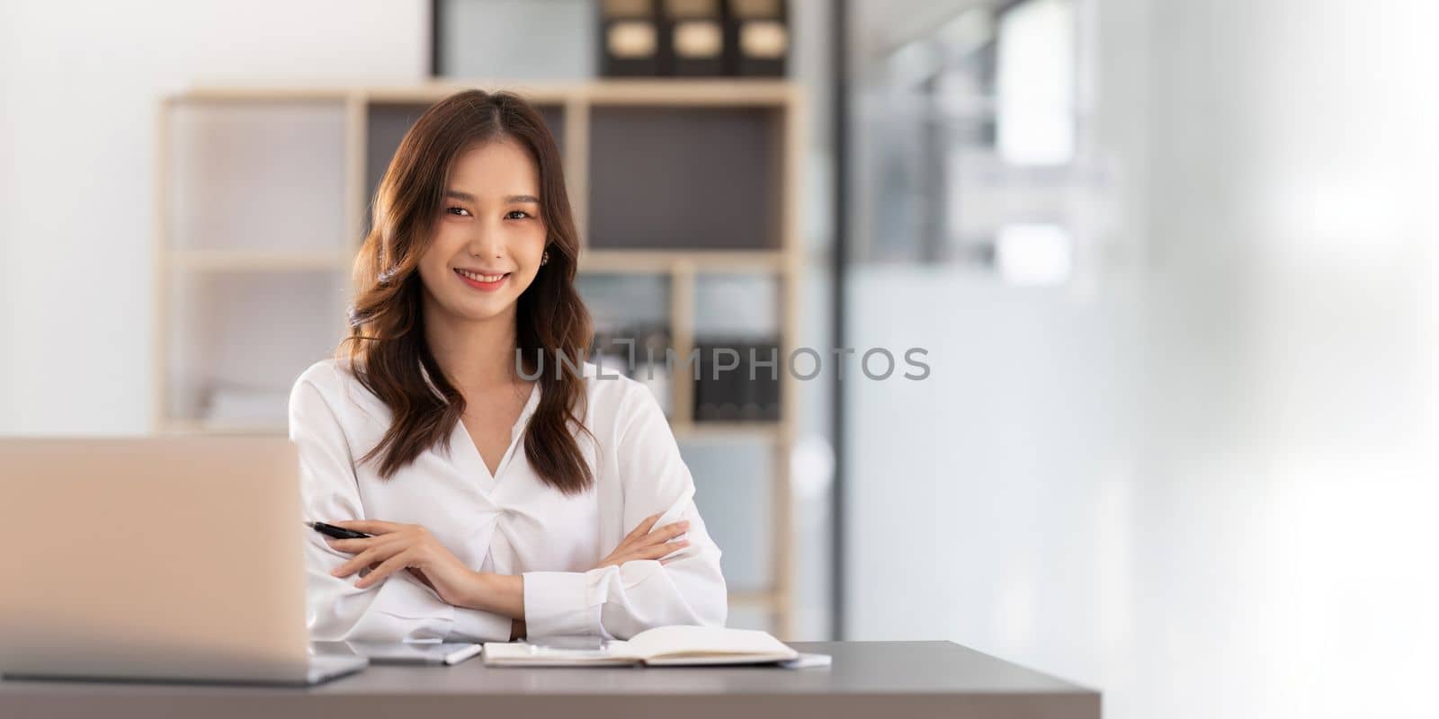 Young businesswoman working on laptop in office.