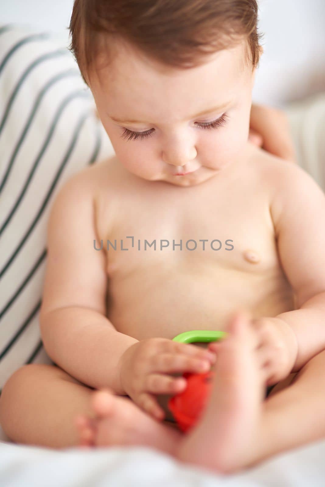 Whats going on over here. an adorable baby girl playing with a toy. by YuriArcurs