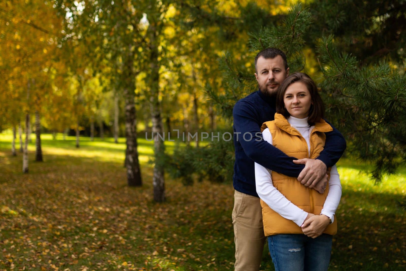 happy classic traditional family hugging against autumn forest background.