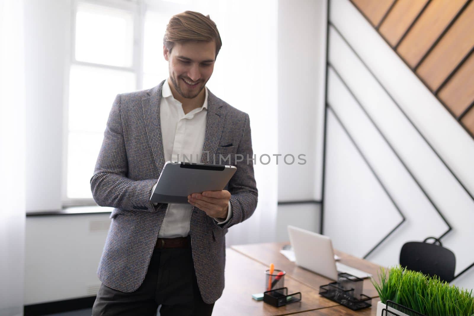 business man with a tablet in his hands IN A STYLISH OFFICE.